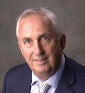 Head and shoulders of Professor Stephen Buckman, Executive Director, Physical Sciences, Engineering, Mathematics and Information Sciences, wearing navy suit with a white shirt and patterned tie.