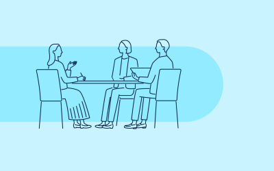 Illustration of three people sitting around a table, engaged in discussion. Two individuals are on one side with laptops, and one person on the opposite side holding a pen and paper. The background is light blue with a darker blue rounded rectangle behind the group.