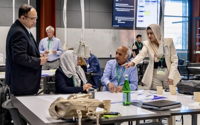 Four people gathered around a table, in discussion. 
