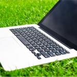 opened laptop on a bed of grass