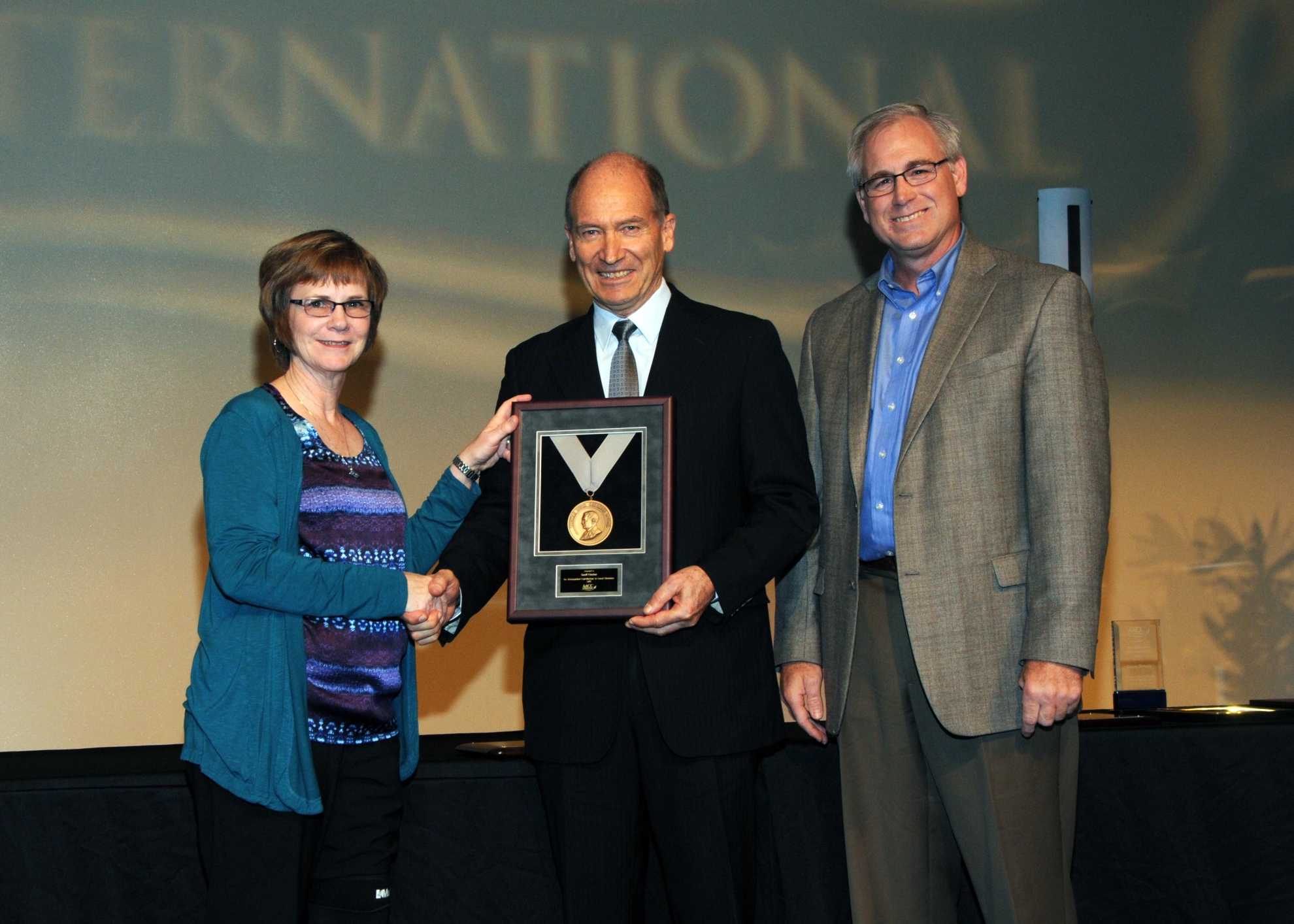 Image courtesy AACC International. L to R: Dr Deborah Rogers, Chair of the AACC International Board, Professor Geoff Fincher and Dr David Hahn, President of AACC International at the award ceremony.