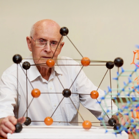 Professor Richard Robson from the University of Melbourne, co-recipient of the 2025 Nobel Prize in Chemistry, sitting in front of a molecular model.