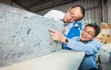 Image: USQ's Dr Zuhua Zhang (left) and Professor Hao Wang examine a geopolymer casting made using fly ash, a waste product of coal-fired power stations.