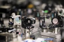 A network of optical devices – mirrors, beamsplitters, and optical fibres – weave laser light into an optical quantum processor. A network of optical devices – mirrors, beamsplitters, and optical fibres – weave laser light into an optical quantum processor.