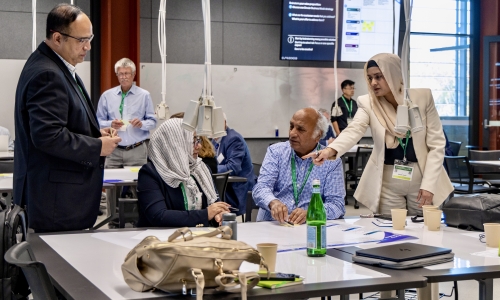 Four people gathered around a table, in discussion. 