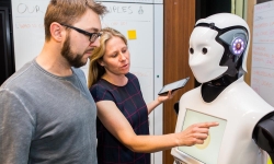 Magic Lab PhD students working in the CBA Innovation Lab on Human-Robot Interaction Experiments with CBA Customers.