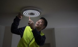 Dr Wen Hu checking one of the hallway lights meshed into the smart building network.
