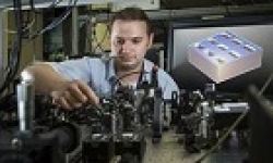 Image: Dr Kruk next to a diagram of the metamaterial structure. Image Stuart Hay, ANU.