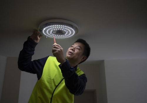 Dr Wen Hu checking one of the hallway lights meshed into the smart building network.
