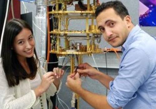 two students holding wires and device