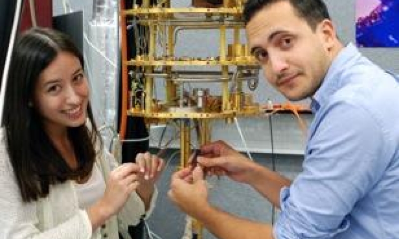 two students holding wires and device