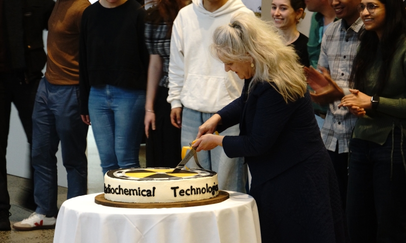 A group of people gathered around a table with a cake that has