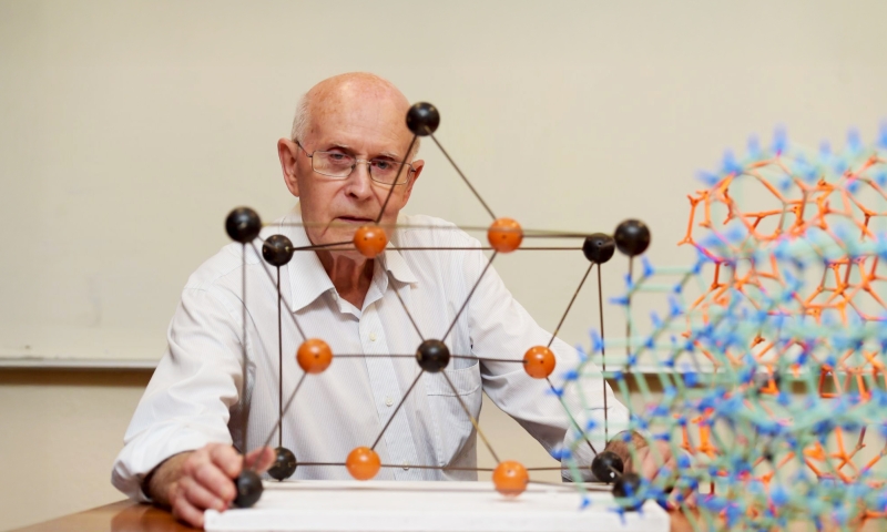 Professor Richard Robson from the University of Melbourne, co-recipient of the 2025 Nobel Prize in Chemistry, sitting in front of a molecular model.