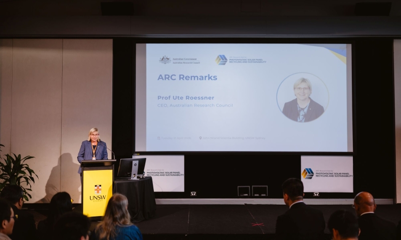 ARC CEO Professor Ute Roessner stands at a lectern at UNSW Sydney, delivering remarks during the official launch of the ARC Research Hub for Photovoltaic Solar Panel Recycling and Sustainability, with the presentation screen visible behind.