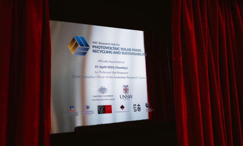 A commemorative plaque marking the official launch of the ARC Research Hub for Photovoltaic Solar Panel Recycling and Sustainability on 21 April 2026 is displayed between red curtains.