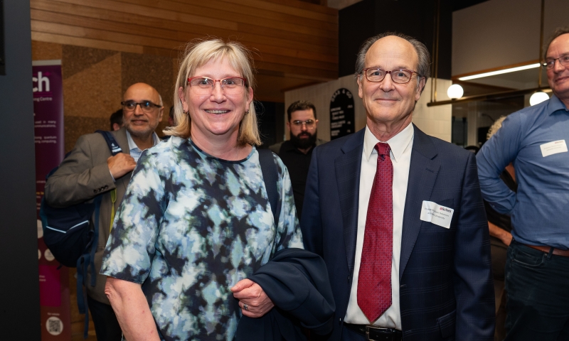 ARC CEO, Prof Ute Roessner and Prof Glenn Solomon standing together facing the camera, with other attendees and displays visible in the background.